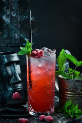 A cooling drink. Raspberry lemonade with tonic, ice and mint in a glass. Cocktails. Bar menu.