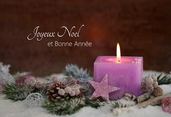 Carte de Noël : Une bougie rose avec des décorations de Noël et des branches de sapin sur la...