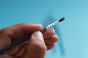 a close up of a hand holding a painting brush