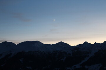 Verbier sunset with crescent moon and last vestiges of daylight (Canton Valais, Switzerland)