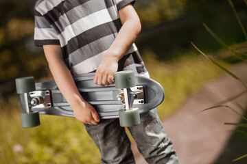 Close up picture of a kids hand holding a skateboard © Oleksandr