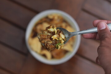 a close up of a ready-to-serve bowl of chicken porridge