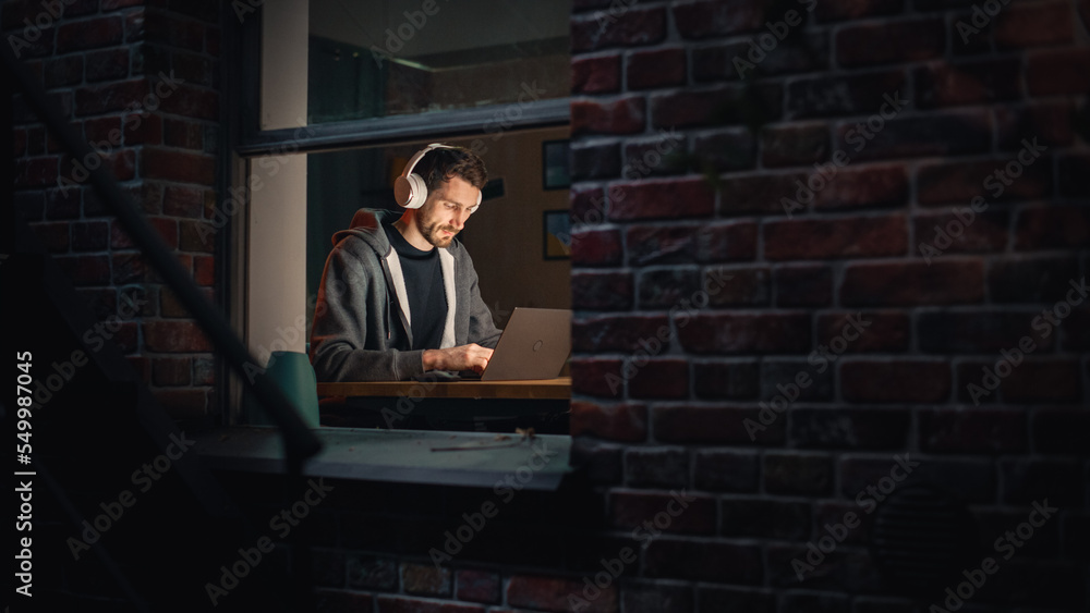 Poster software developer programming on a laptop late at night. male specialist browsing internet, listeni