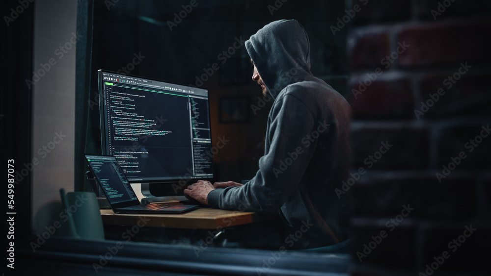 Poster Night Apartment: Evil Greedy Hacker Wearing Hoodie, Breaks into Data Servers, Does DDOS Attack, Phishing Scheme, Malware, Sends Virus. Cyber Security and Crime Concept. View From Outdoors into Window.