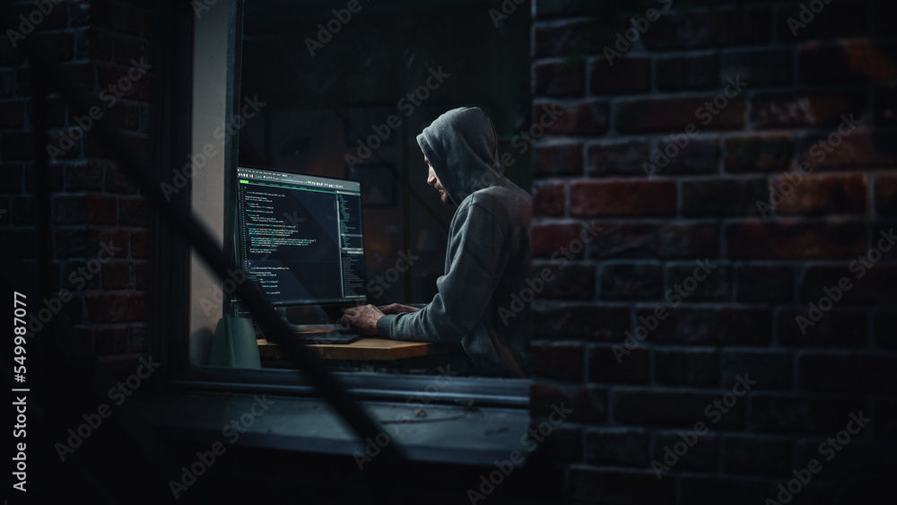 Poster night apartment: evil male hacker wearing hoodie breaks into data server room, ddos attack, phishing