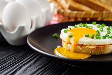 delicious fried egg sandwich on black rustic wooden background