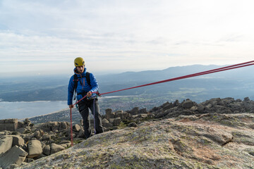 Man going down mountain with rope