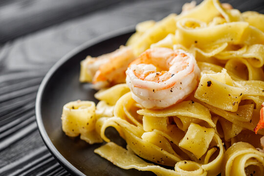 delicious shrimp fettuccine alfredo pasta on a black rustic background