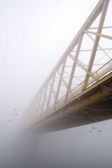 Spooky winter landscape showing bridge over river on a misty winter day