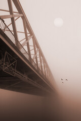 Spooky winter landscape showing bridge over river on a misty winter day