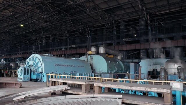 Turbine hall of a coal-fired thermal power plant. Engine room for generating electricity. Smoke from chimneys, metal structures in a factory.