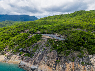 Fototapeta na wymiar Aerial view of tropical road around rainforrest and ocean