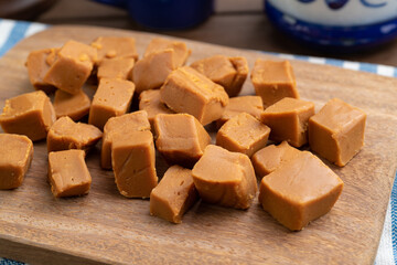 Doce de leite or dulce de leche, traditional south american milk candy over wooden board