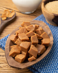 Doce de leite or dulce de leche, traditional south american milk candy with ingredients over wooden table