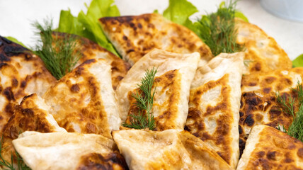 A plate with many pasties with meat. Delicious fried pasties, a traditional dish.