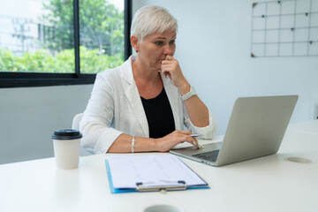 Successful businesswoman working with laptop at her office desk, Concept of business risk analysis and assessment