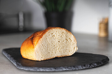 White yeast cut loaf on a carved cutting board in the kitchen. Close-up
