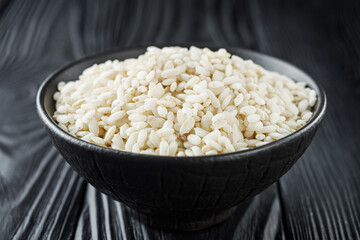 arborio rice for risotto on a black wooden background