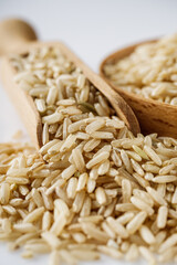 raw unpolished rice on a white acrylic background