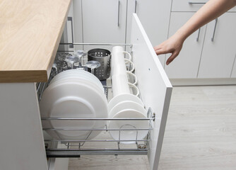 Pull-out shelf with dishes in a modular kitchen. Modern kitchen furniture. Production of kitchens...