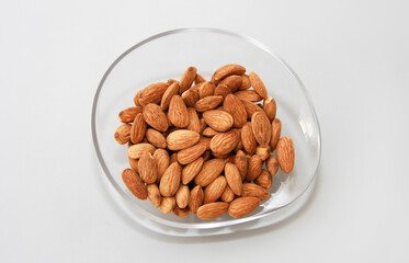 small grains of natural dry brown almonds in a decorative plate