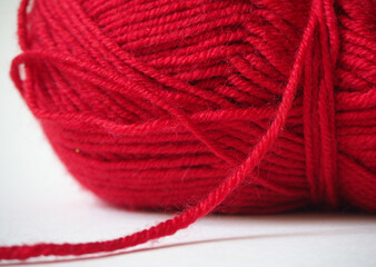 Ball of red yarn on white background.
