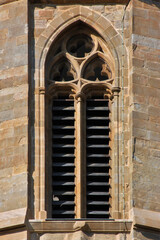Pointed abat-son window with gothic tracery at the medieval cathedral tower of St Michel in...