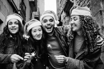Happy young diverse people having fun celebrating with bengal sparkler in winter time - Christmas...