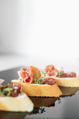 Appetizer with prosciutto, bruschetta and sun-dried tomato. Food, restaurant and event concept.