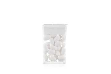 Transparent plastic box with white candies on a white background.