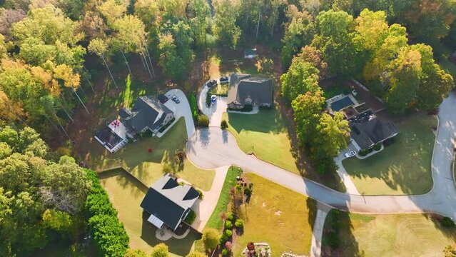 Aerial view of new family houses between yellow trees in South Carolina suburban area in fall season. Real estate development in american suburbs