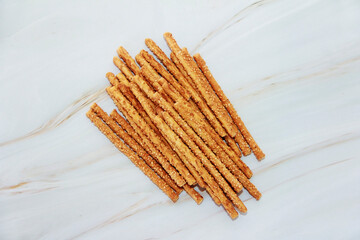 baked dry long bread sesame sticks on a marble background