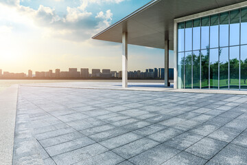 Empty square floor and glass wall building with city skyline in Shanghai, China.