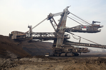 Bucket-wheel excavator during excavation at the surface mine. Huge excavator on open pit mine.