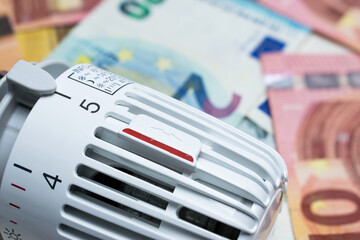 Heating thermostat on euro money banknotes. Rising costs for heat and energy concept.