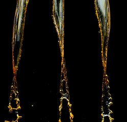 Orange, lemon juice or oil lubricant splash, liquid gold yellow drink drops. Fruit beverage water elements in line form . Fresh splashing and flowing jets, black background isolated freeze motion
