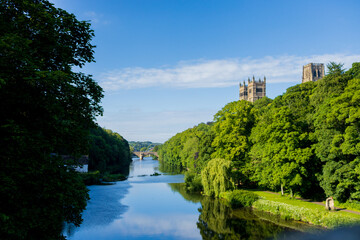 Fototapeta na wymiar Durham England: 2022-06-07: Durham Cathedral exterior during sunny summer day. View from river wear with lush green trees