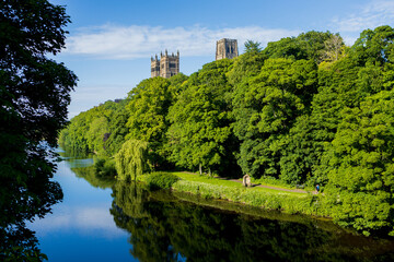 Durham England: 2022-06-07: Durham Cathedral exterior during sunny summer day. View from river wear with lush green trees