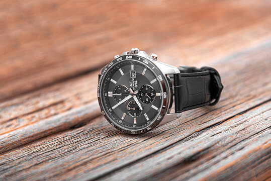 UZHGOROD, UKRAINE - JUNE 28, 2016: Modern Men's Watch CASIO EDIFICE with a leather strap, on a wooden background, on June 28, 2016 in Uzhgorod, Ukraine.