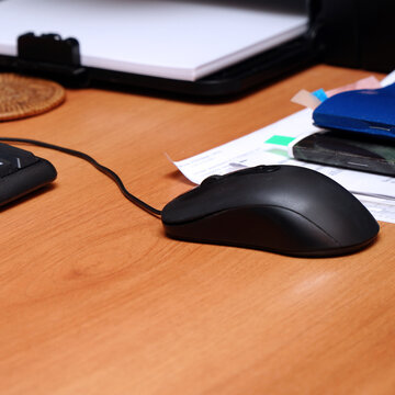 Black computer mouse on the desktop in the office
