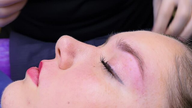 Brushing eyebrows with a brush. Cosmetic procedure permanent eyebrow makeup. Eyebrow tattooing.