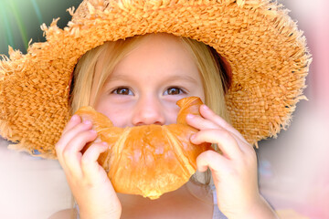 close-up of child's face, girl 3 years old holds rosy baked croissant with hands near mouth,...