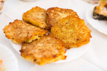 Fried grated potato pancakes with sour cream on white plate