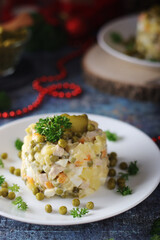 Olivier salad, traditional Russian dish, served on the plate for New Year dinner