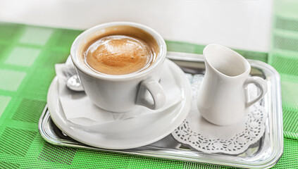 Cup of coffee with a delicious foam on the table.