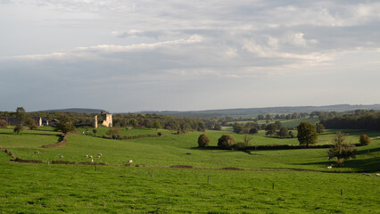 Fototapeta premium Wonderful landscape photography in France. landscape photo in Burgundy. landscape photo in the Nievre. Meadow with Church with sun. 58 in France