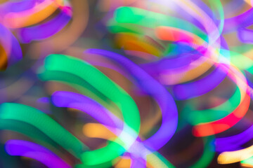 Glowing multicolored neon stripes of light similar as springs close up. Motion on long exposure.
