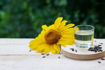 Close-up of sunflower oil in glass with seeds and sunflower