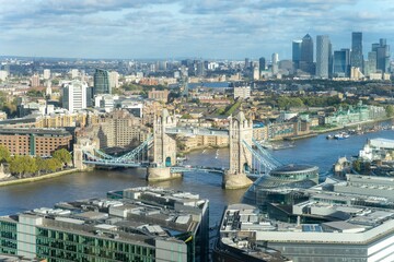 Aerial view of Tower Bridge and London cityscape under the blue cloudy sky