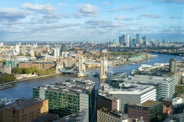 Aerial view of Tower Bridge and London cityscape under the blue cloudy sky